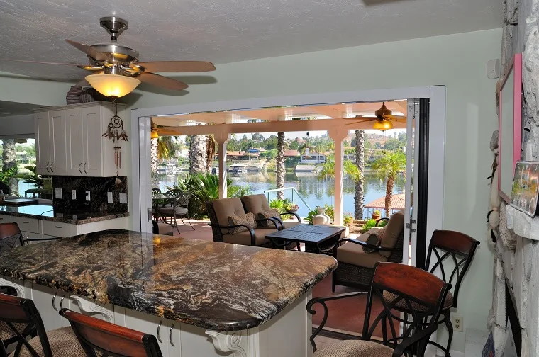 Lanai folding glass doors connecting a kitchen and living space to a covered patio