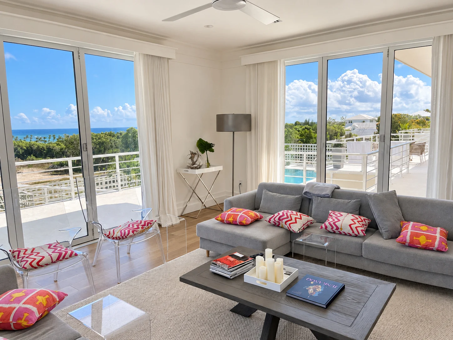 Bright coastal living room with white bifold doors framing an ocean view