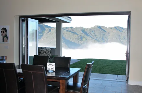 Clad folding doors opening a dining area to a mountain-view patio.