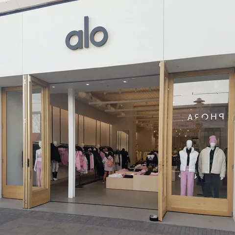 An open wood folding-door storefront facing a shopping walkway.