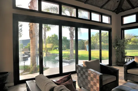 Thermally broken aluminum doors enclosing a timber-ceilinged living space.