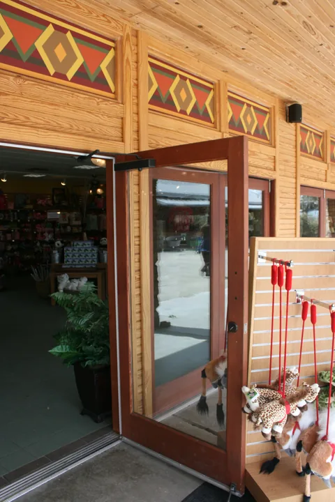 Wood folding doors below decorative beams at a visitor venue.