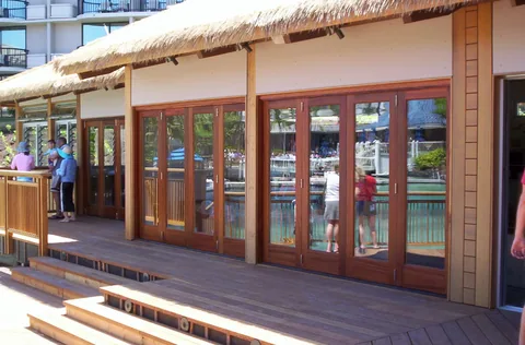A long row of wood folding doors beside an outdoor walkway.