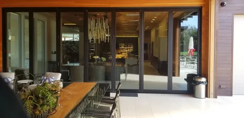 Aluminum folding doors between a dining space and covered terrace.