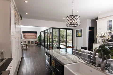 Kitchen and dining room with closed aluminum corner doors overlooking the deck.