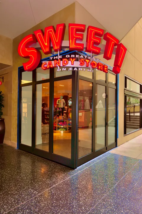 Sweet candy-store entrance with aluminum corner doors closed.
