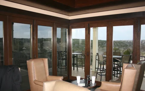 Clad folding panels surrounding a timber-ceilinged room.