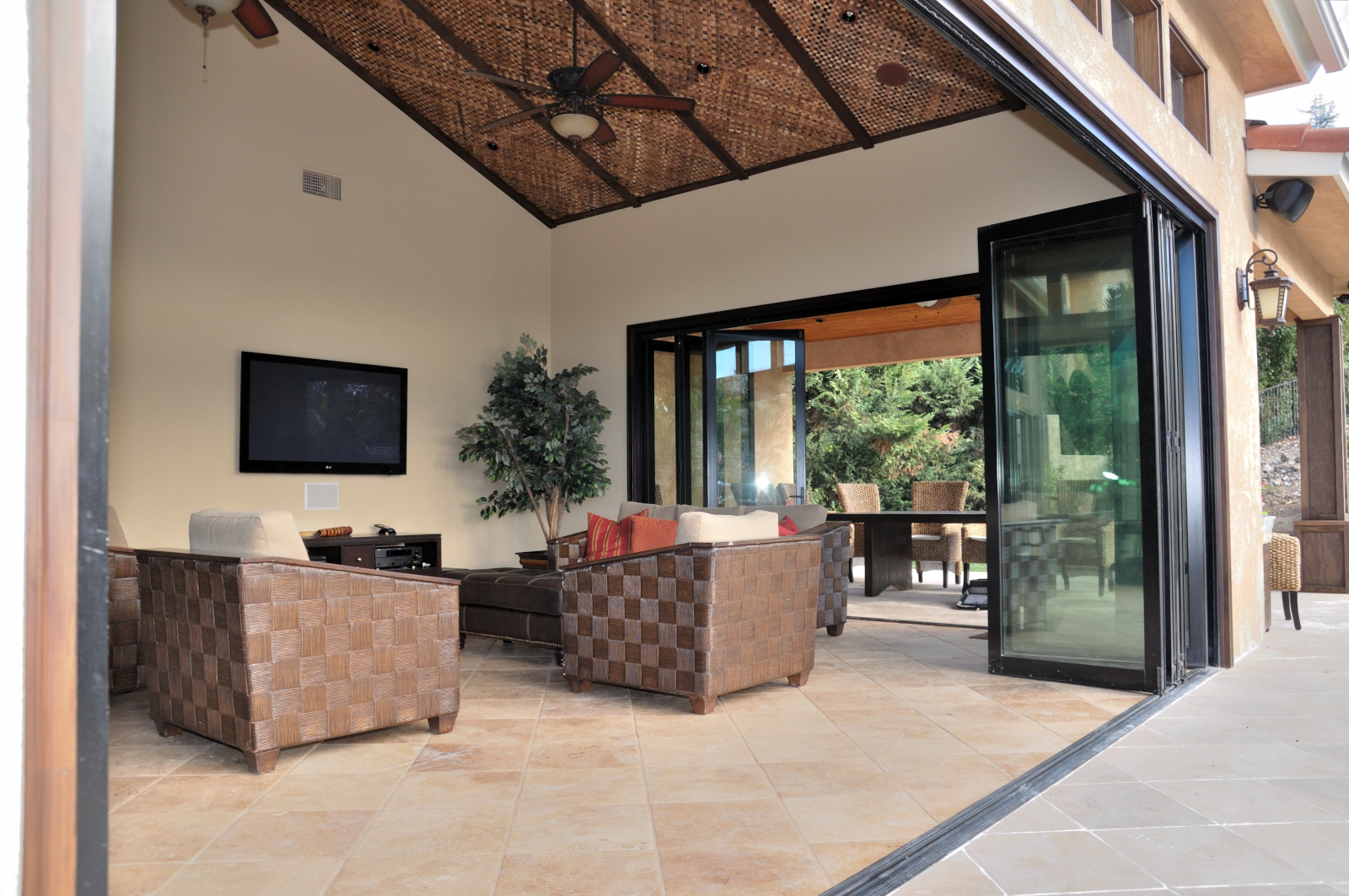 Luxury indoor-outdoor living space with large folding glass wall system.