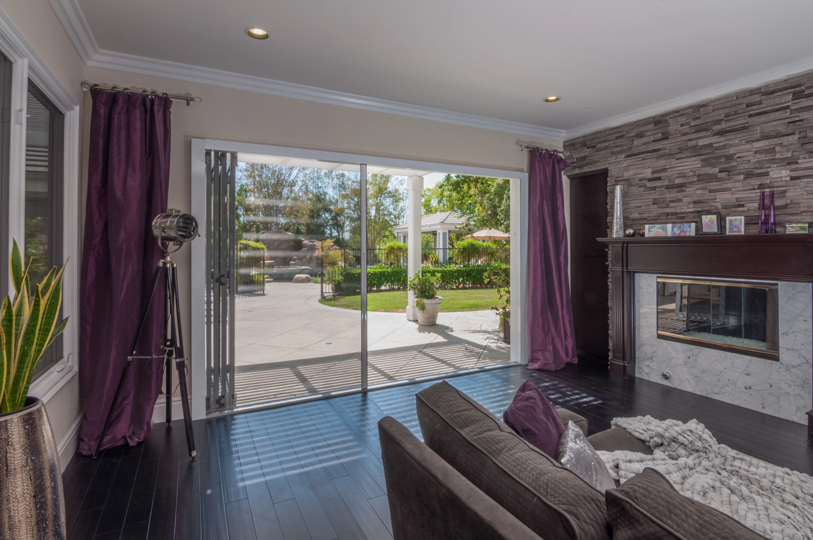 High-end hospitality patio with large glass opening with retractable screen creating a large indoor-outdoor opening.