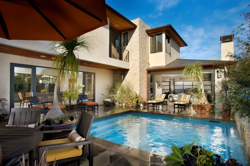 High-end home with folding glass wall connecting living room to pool patio.