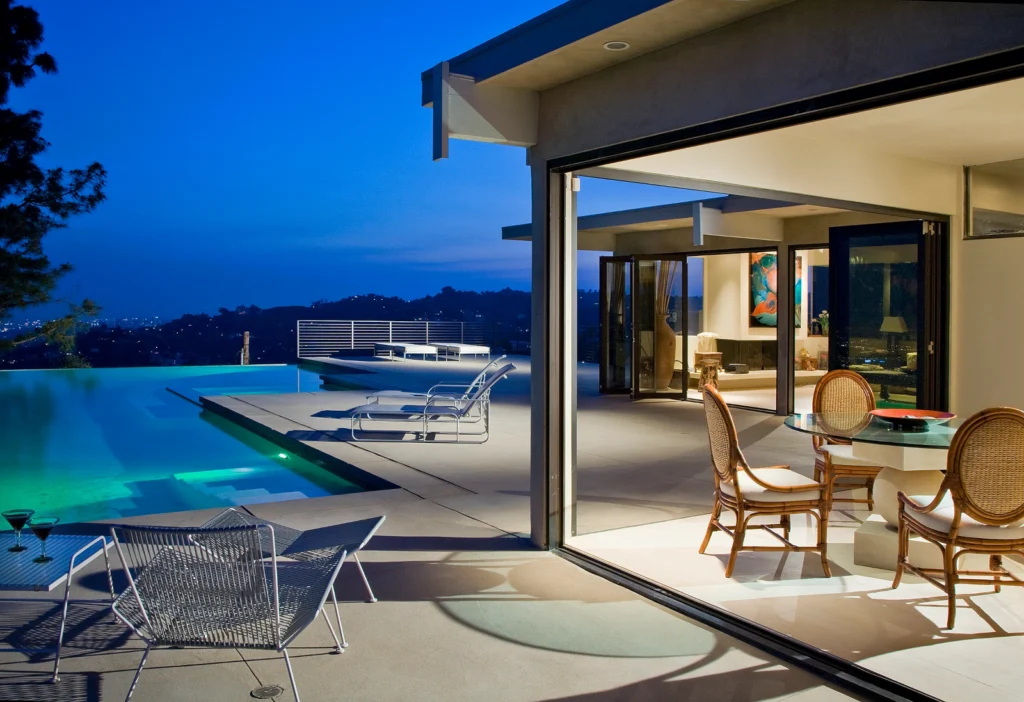 Luxury Los Angeles hillside terrace with infinity pool and bifolding glass wall systems.