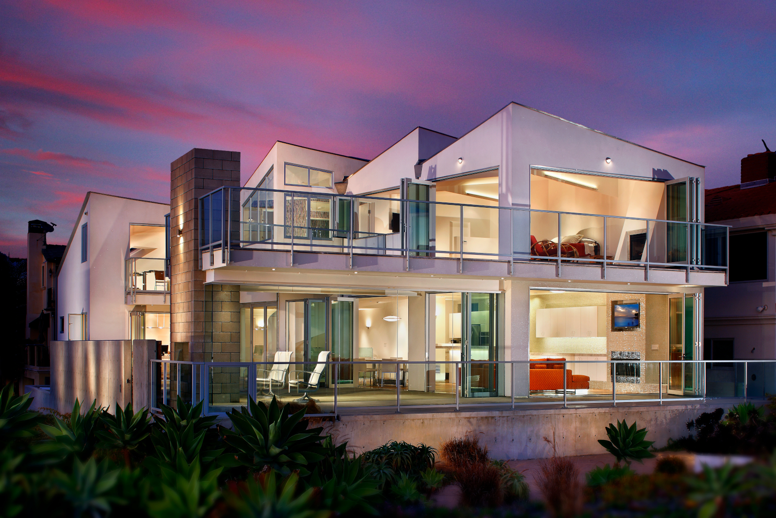 Modern beachfront residence with large glass openings and folding patio doors.
