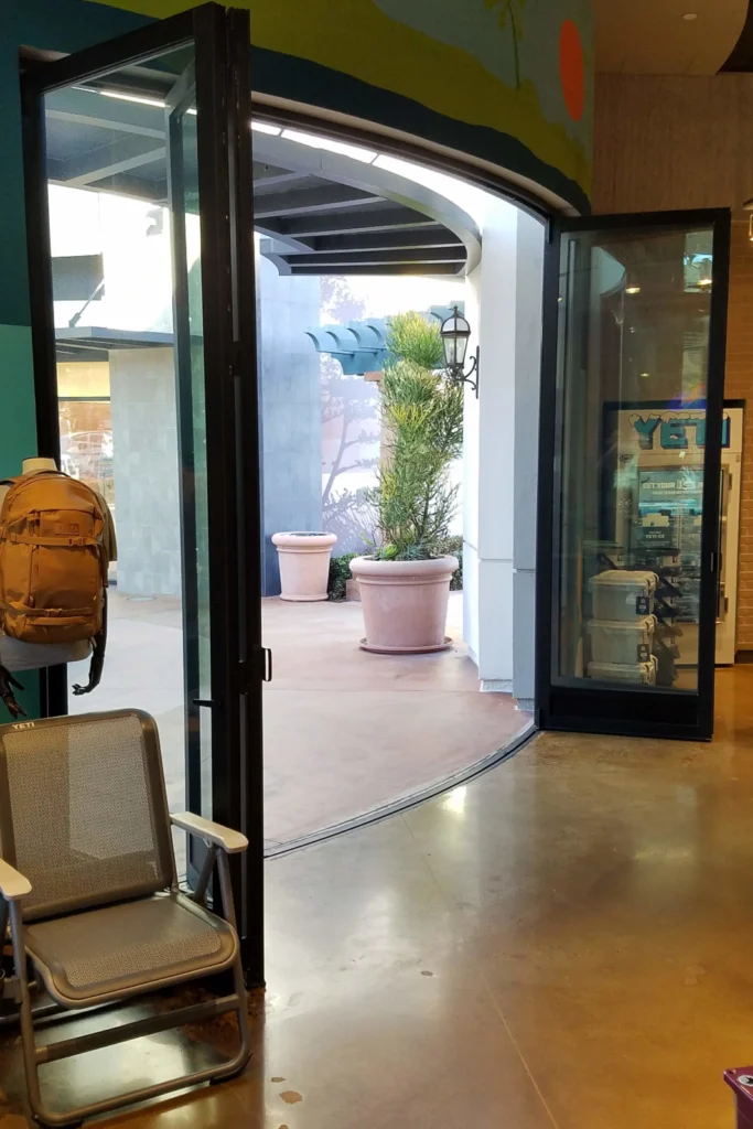 Radius aluminum storefront folding door system creating curved commercial opening.