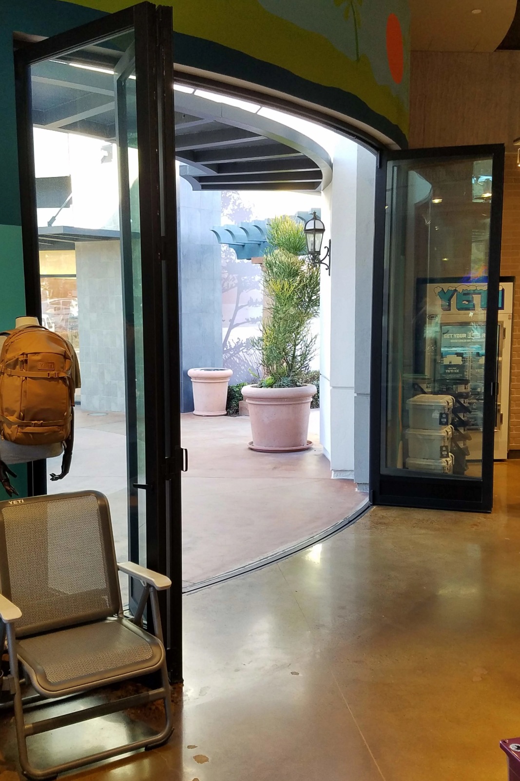 Radius aluminum storefront folding door system creating curved commercial opening.